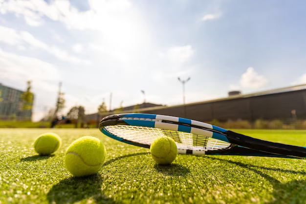 Tennis racket with balls on an empty tennis court