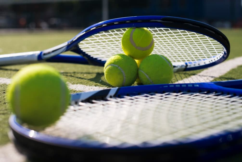 Tennis rackets and balls on grass court