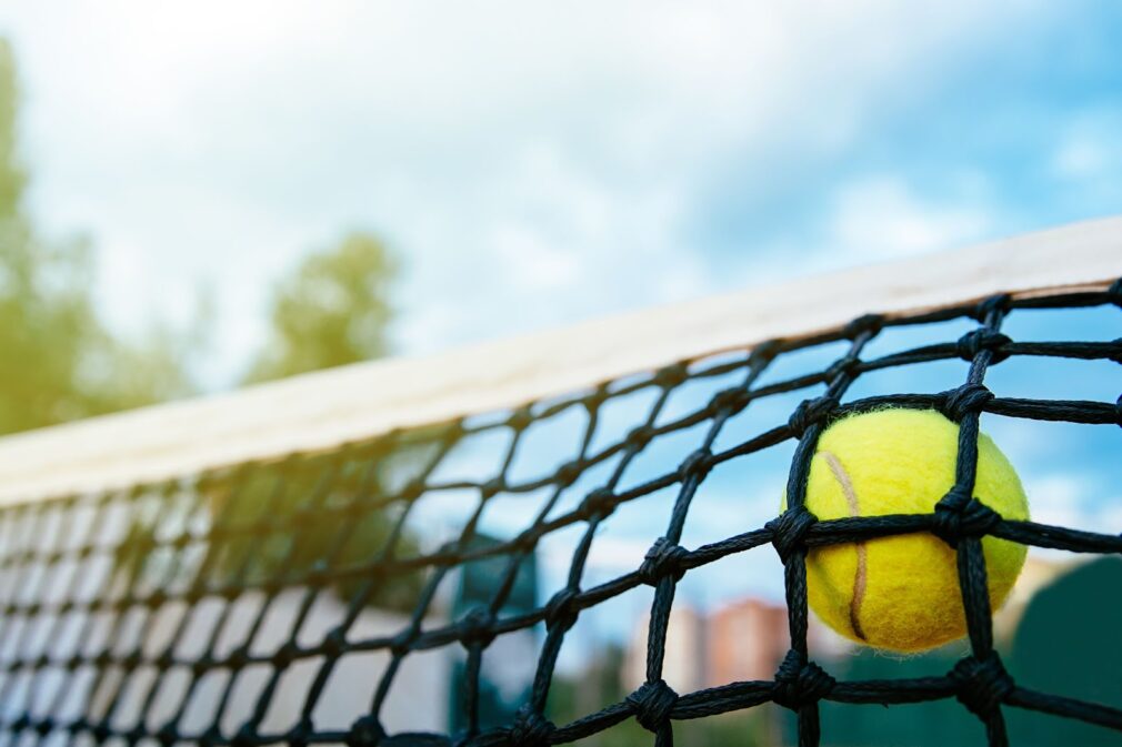 Close up photo of tennis ball hitting net