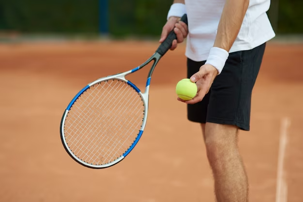 A man standing with a tennis racket and a tennis ball