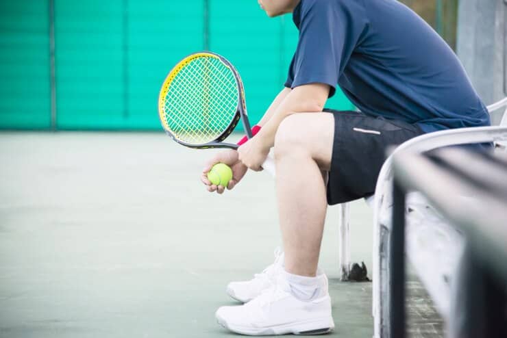 Tennis Player Sitting in the Court After Match